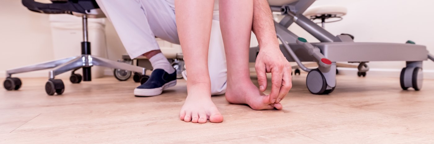 Ein Arzt überprüft die Füße eines Patienten 