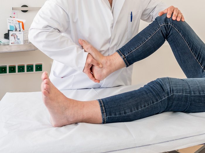 Ein Arzt überprüft Knie und Ferse eines Beins